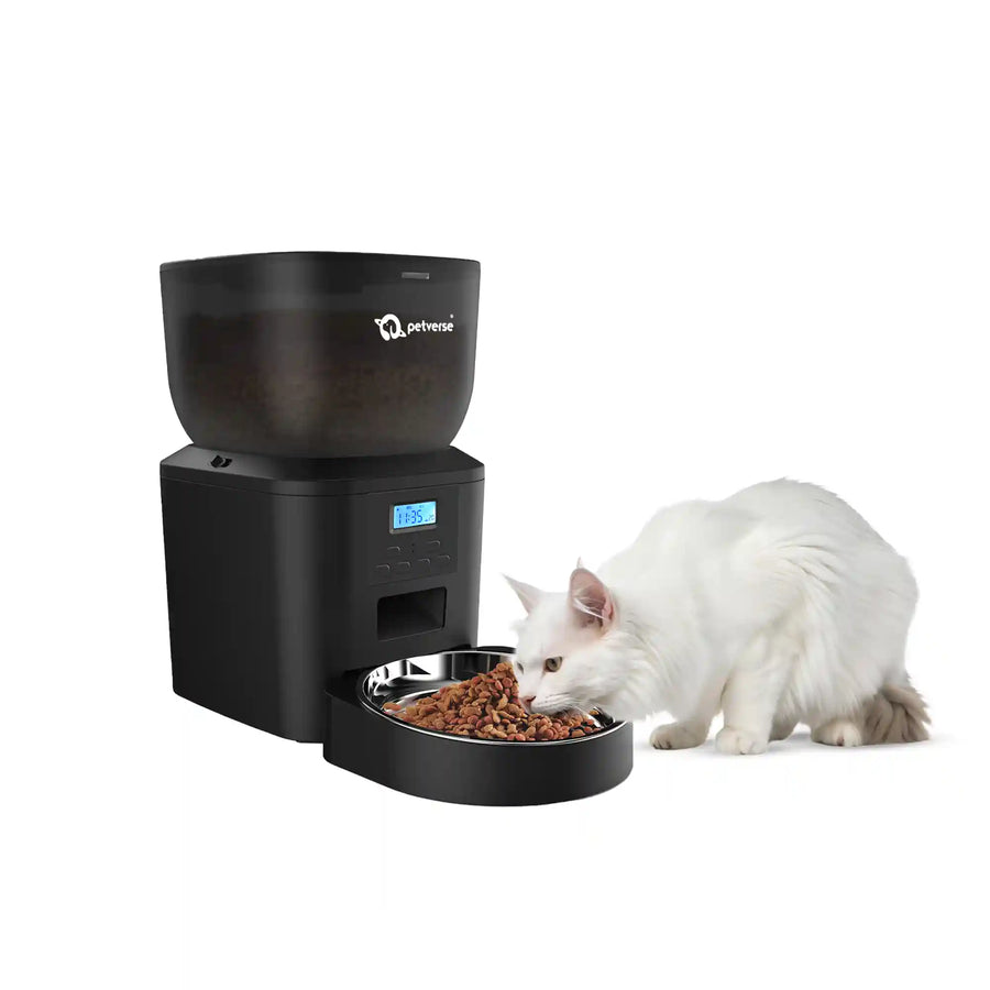 A cat eating from a black automatic pet feeder with a digital display and food bowl.