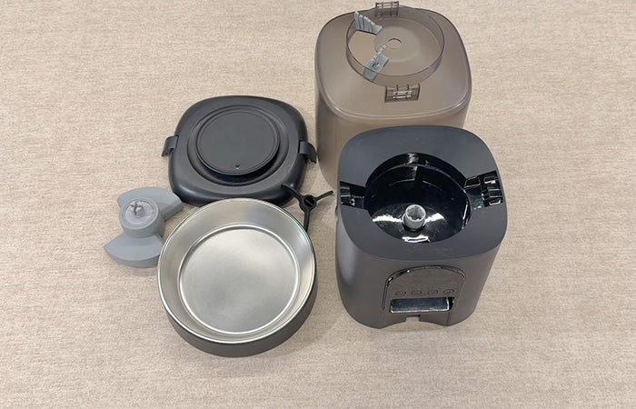 Three cylindrical containers with lids on a beige surface
